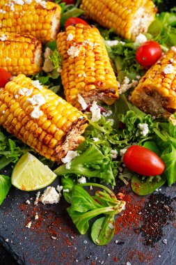 Lezzetli fırında Mısır pişmiş beyaz peynir, kırmızı biber, limon, sebze ile.