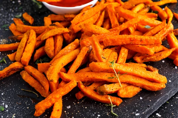 Hälsosam hemlagad bakade Orange Batat frites med Ketchup, örter, salt och peppar. — Stockfoto