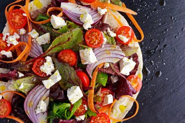 Vejetaryen ekmeği taco film kırmızı soğan, tatlı kiraz domates, havuç, Ruby on Rails pazı, roket ve beyaz peynir ile drizzled zeytin yağı