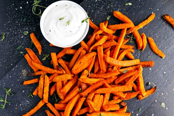 Healthy Homemade Baked Orange Sweet Potato Fries with fresh cream dip souce, herbs, salt and pepper. — Stock Photo, Image