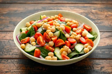 Domatesli nohut salatası, salatalık, kırmızı soğan ve yeşillik. Beslenme yemeği. Vegan salatası.