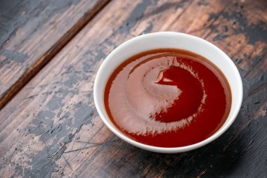 Ahşap masada beyaz kasede barbekü sosu.