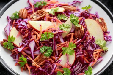 Havuçlu, elmalı ve cevizli kırmızı lahana salatası. Sağlıklı vejetaryen yemekleri