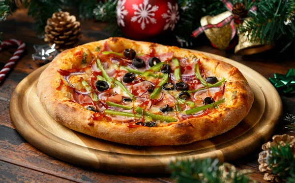 Pizza grillowa z dekoracją, prezenty, zielona gałąź drzewa na drewnianym rustykalnym stole. — Zdjęcie stockowe