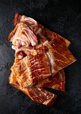 Çizgili domuz pastırmalı pancetta. Odun parçasında tütsülenmiş.