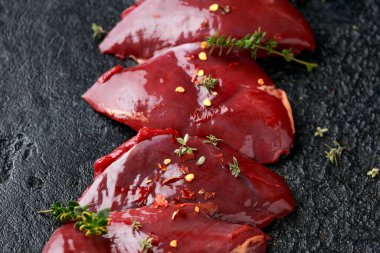 Güvercin göğsü filetoları ahşap tahtada baharat karışımıyla pişirmeye hazır.