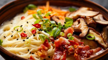 Domuz kemiği Japon usulü ramen çorbası kıtır pastırma, şitake mantarı ve killi kasede taze soğan.