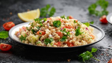 Domates, salatalık, kırmızı soğan, bulgur ve maydanozlu Tabbouleh salatası. Sağlıklı vejetaryen yemekleri