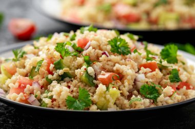 Domates, salatalık, kırmızı soğan, bulgur ve maydanozlu Tabbouleh salatası. Sağlıklı vejetaryen yemekleri