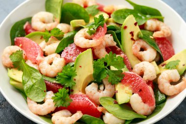 Beyaz tabakta taze Avokado Greyfurt karides salatası