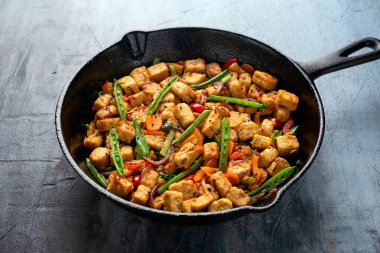 Vejetaryen eti ücretsiz micoprotein parçaları sebze kızartması dökme demir tavada servis edilir.