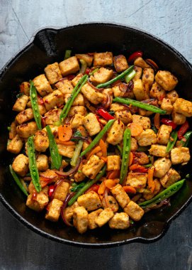 Vejetaryen eti ücretsiz micoprotein parçaları sebze kızartması dökme demir tavada servis edilir.