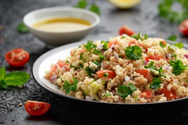 Domates, salatalık, kırmızı soğan, bulgur ve maydanozlu Tabbouleh salatası. Sağlıklı vejetaryen yemekleri