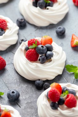 Meringue yuvası mini pavlova keki taze çilekli böğürtlen ahududu ve sağlıklı çöl için naneli.