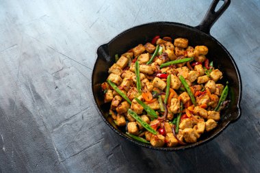 Vejetaryen eti ücretsiz micoprotein parçaları sebze kızartması dökme demir tavada servis edilir.