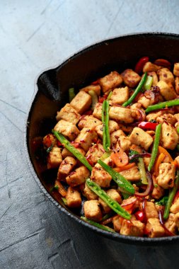 Vejetaryen eti ücretsiz micoprotein parçaları sebze kızartması dökme demir tavada servis edilir.