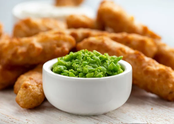 Battered Haddock fish, mini fingers with mashed peas, tartar sauce on white wooden board — Stock Photo, Image