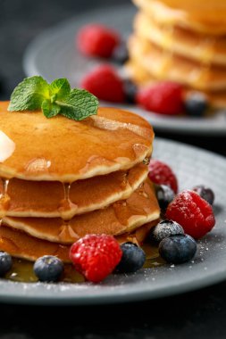 Taze yaban mersinli Amerikan gözlemeleri, ahududu ve bal. Sağlıklı sabah kahvaltısı