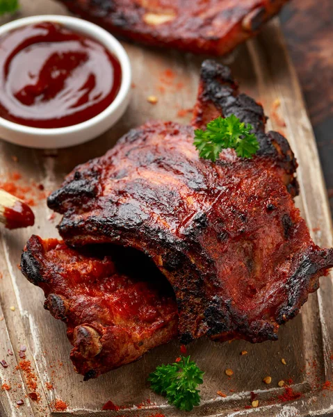 Costillas de cerdo a la parrilla con hierbas sobre tabla de madera — Foto de Stock