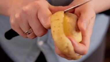 Keskin bıçakla patates soyan bir kadın. Videoyu kapat