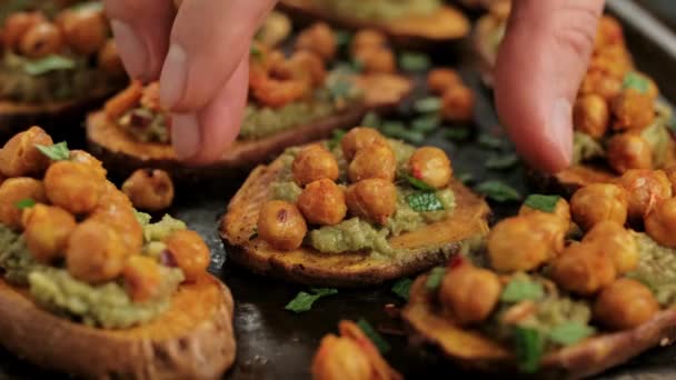 Man Hand pick Sweet potato toast loaded with avocado guacamole and baked chickpeas. — Stock Video