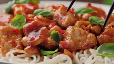 Yemek çubuğuyla kaseden erişteli tatlı biberli tavuk topluyorum. Asya yemekleri.