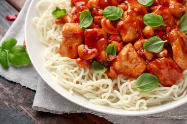 Ahşap masada erişteli tatlı biberli tavuk. Asya yemekleri..