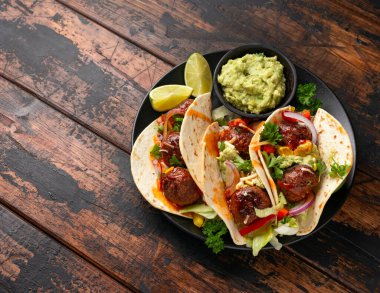 Etsiz pancar kökü ve bezelye proteini köfteli dürüm avokado soslu dürüm, acı biber sosu ve limon dilimleri.