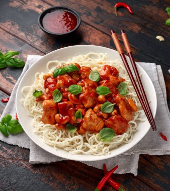 Ahşap masada erişteli tatlı biberli tavuk. Asya yemekleri.