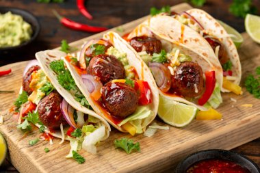 Etsiz pancar kökü ve bezelye proteini köfteli dürüm avokado soslu dürüm, acı biber sosu ve limon dilimleri.