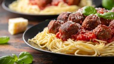 Etsiz vejetaryen spagetti, bol domates soslu vejetaryen köfte, rendelenmiş peynir ve fesleğen yaprağı.