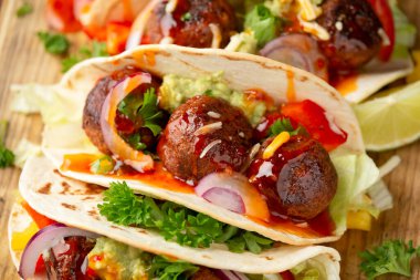 Etsiz pancar kökü ve bezelye proteini köfteli dürüm avokado soslu dürüm, acı biber sosu ve limon dilimleri.