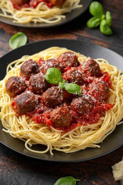 Etsiz vejetaryen spagetti, bol domates soslu vejetaryen köfte, rendelenmiş peynir ve fesleğen yaprağı.