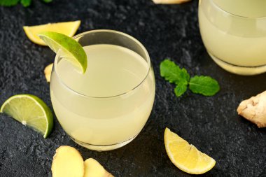 Zencefilli ve limonlu gazoz, yanında limon dilimleri olan bardaklarda köpüklü içecek.