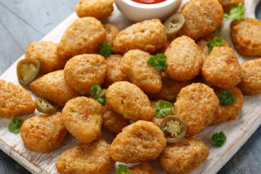 Beyaz tahta üzerinde krem peynirli gevrek Jalapeno Popper.