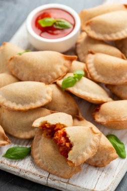 Margarita Margherita pizza paketleri içi domates, mozzarella peyniri ve fesleğen dolu cepleri beyaz tahta tahtada servis edilir. Parti yemeği.