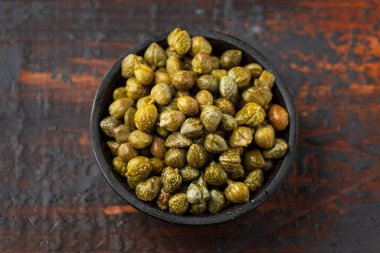 Ahşap bir kasede marine edilmiş turşulu kapari