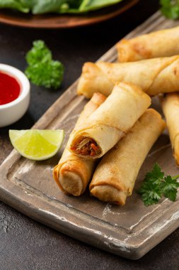 Kızarmış sebzeli börek ve ahşap tahtada soya sosu.