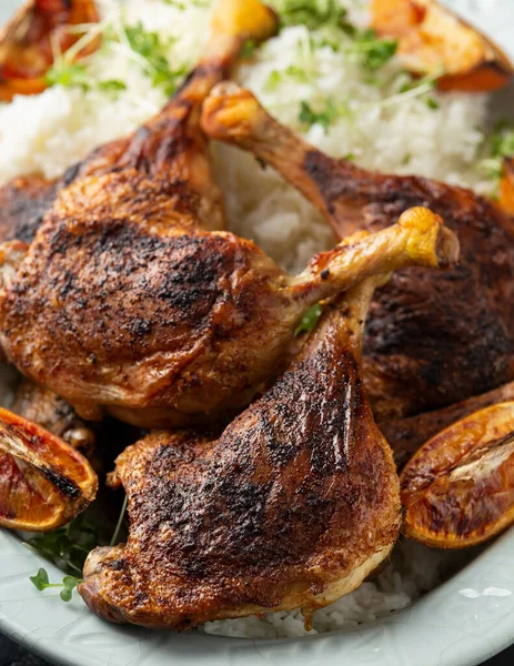 Patas de pato aromáticas cocidas lentamente con arroz basmati y ensalada lateral servida con cuñas de naranja. — Foto de Stock