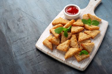 Tahta üzerinde susam tohumu ve acı biber soslu Asya geleneksel karides tostu.