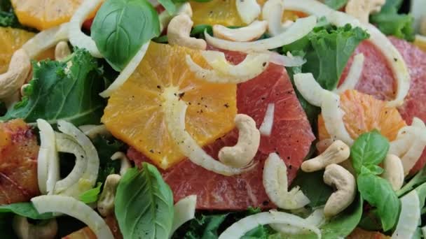 Свежий салат с фенхелем, апельсином, грейпфрутом, шпинатом и орехами кешью. здоровую пищу. вращающееся видео — стоковое видео