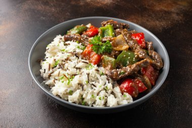 Çin biberli biftek, soğan, kırmızı ve yeşil dolmalık biber, kasede pilav.