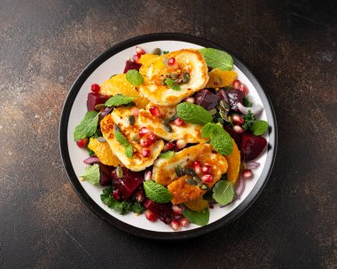 Fried Halloumi Cheese salad with beetroot, orange, pomegranate and pumpkin seeds, red onion, green vegetables. healthy food clipart