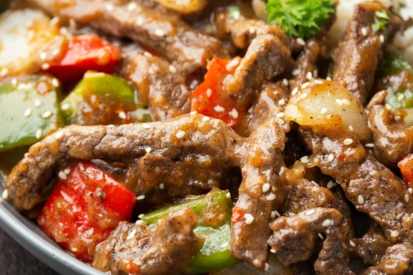 Chinesisches Rindersteak mit Zwiebeln, roter und grüner Paprika, Reis in Schüssel anbraten — Stockfoto