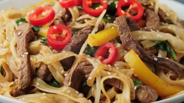 Amestecați carnea de vită Chow Distracție cu tăiței de orez, germeni de fasole, ceapă de primăvară și chili . — Videoclip de stoc