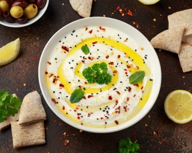 Labneh krem peynirli sos zeytinyağı, tuz, zeytinli otlar, beyaz kasede pide ekmeği