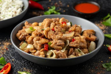 Çin tuzu ve biberli tavuğu gri kasede pilavla karıştır.