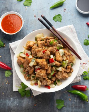 Çin tuzu ve biberli tavuğu kırmızı, yeşil biberli, soğanlı, taze soğanlı, beyaz kasede kızart..