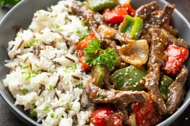 Çin biberli biftek, soğan, kırmızı ve yeşil dolmalık biber, kasede pilav.