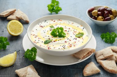 Labneh krem peynirli sos zeytinyağı, tuz, zeytinli otlar, beyaz kasede pide ekmeği